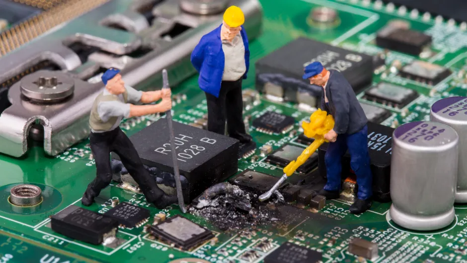Miniaturarbeiterfiguren reparieren defektes Mainboard vom Computer